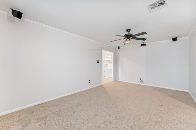 empty room featuring crown molding, carpet floors, and ceiling fan