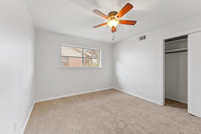 unfurnished bedroom with ceiling fan, a closet, and light carpet