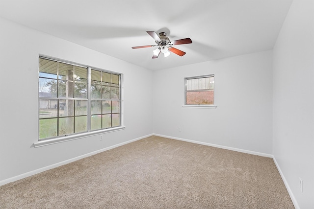 carpeted empty room with plenty of natural light and ceiling fan