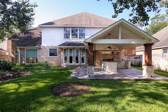 rear view of house with a patio area, ceiling fan, a yard, and exterior kitchen