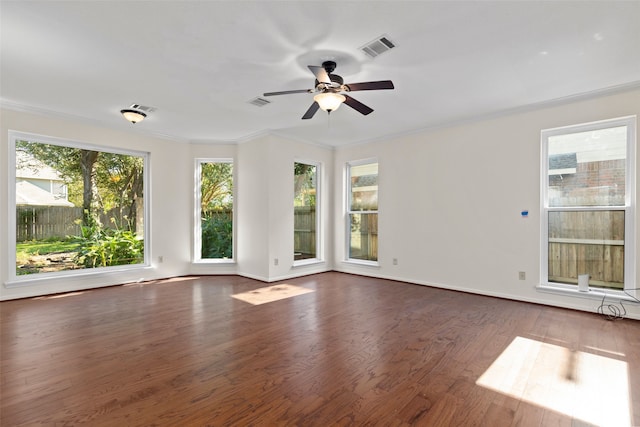 spare room with crown molding, ceiling fan, and dark wood-type flooring