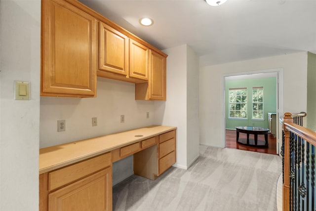 kitchen featuring light carpet and built in desk