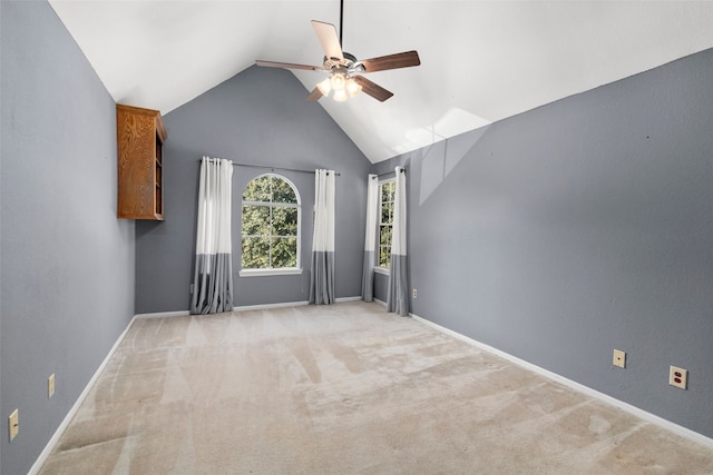 interior space featuring ceiling fan, light colored carpet, and lofted ceiling