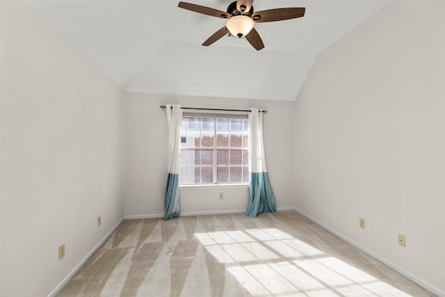 carpeted spare room featuring ceiling fan and vaulted ceiling