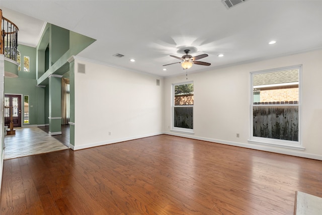 unfurnished living room with hardwood / wood-style floors, ceiling fan, and crown molding