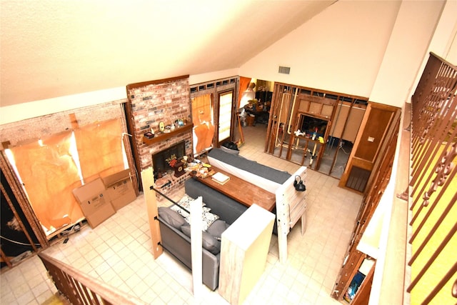 living room featuring vaulted ceiling and a brick fireplace