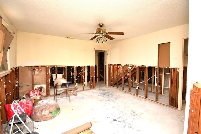 miscellaneous room with a textured ceiling, ceiling fan, and concrete floors