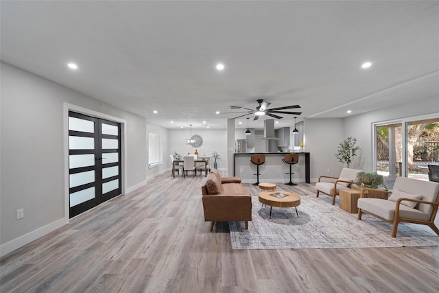 living room featuring ceiling fan, french doors, and light hardwood / wood-style floors