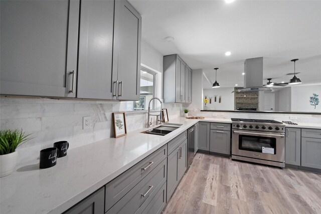 kitchen featuring island exhaust hood, tasteful backsplash, stainless steel appliances, sink, and hanging light fixtures