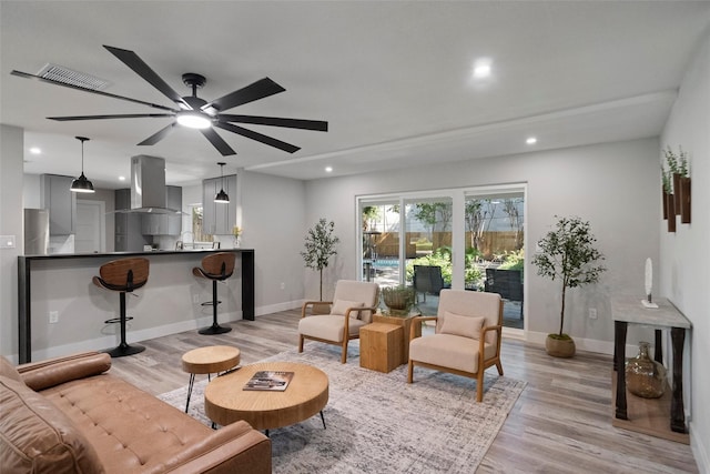 living room with light hardwood / wood-style floors and ceiling fan