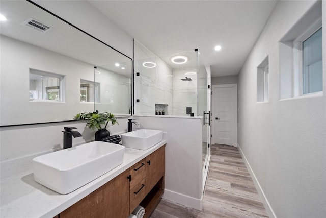 bathroom featuring hardwood / wood-style floors, vanity, and a shower with shower door