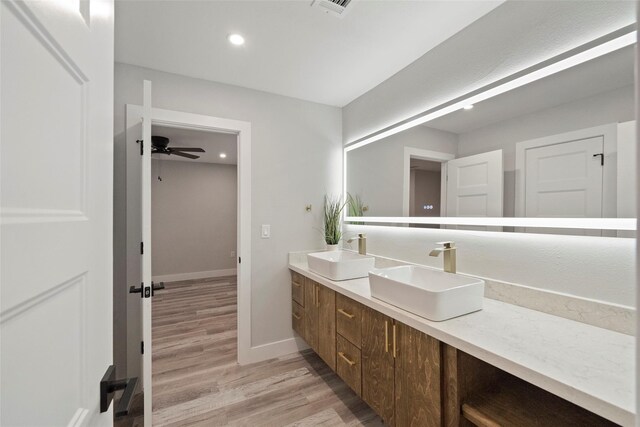 bathroom with wood-type flooring, vanity, and ceiling fan