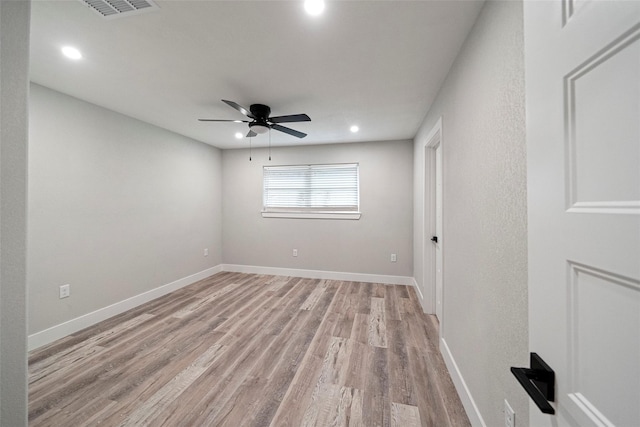 spare room with ceiling fan and light wood-type flooring