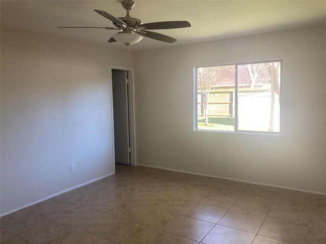 tiled spare room featuring ceiling fan