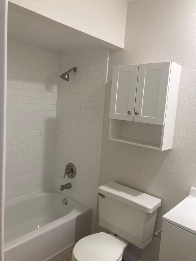 bathroom featuring tiled shower / bath combo and toilet