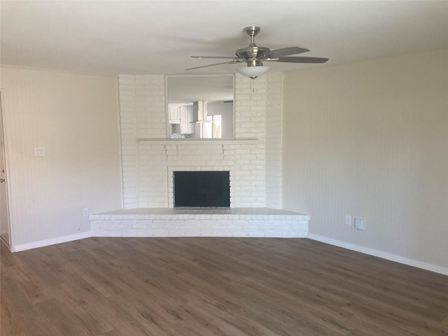 unfurnished living room with ceiling fan, dark wood-type flooring, and a brick fireplace