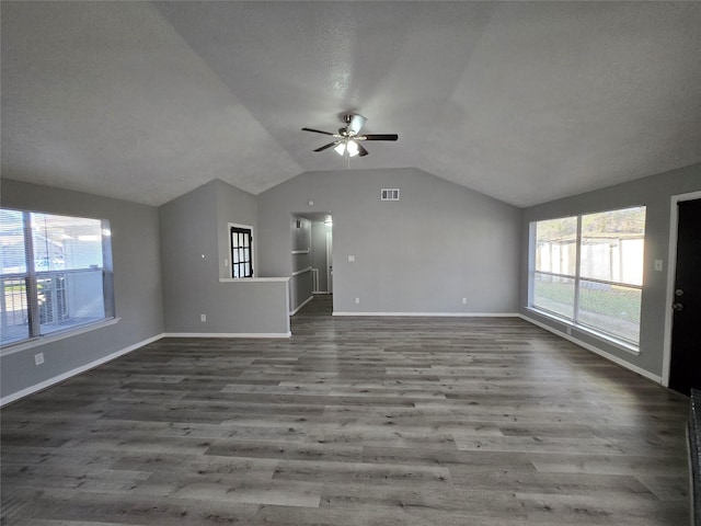 unfurnished living room with ceiling fan, wood-type flooring, a wealth of natural light, and lofted ceiling