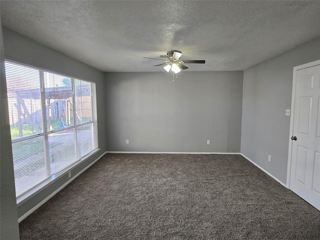 unfurnished room featuring ceiling fan, a textured ceiling, and dark colored carpet