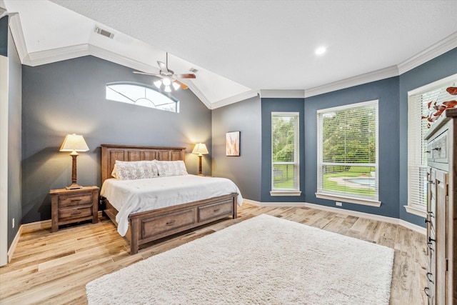 bedroom with ceiling fan, light wood-type flooring, crown molding, and vaulted ceiling