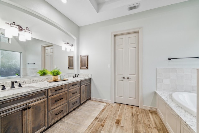 bathroom featuring a tub to relax in and vanity