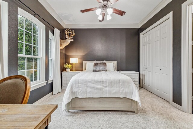 carpeted bedroom featuring a closet, ceiling fan, and crown molding