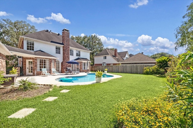 view of swimming pool featuring a patio and a lawn