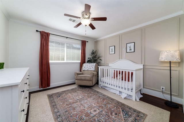 bedroom with ceiling fan, ornamental molding, and a nursery area