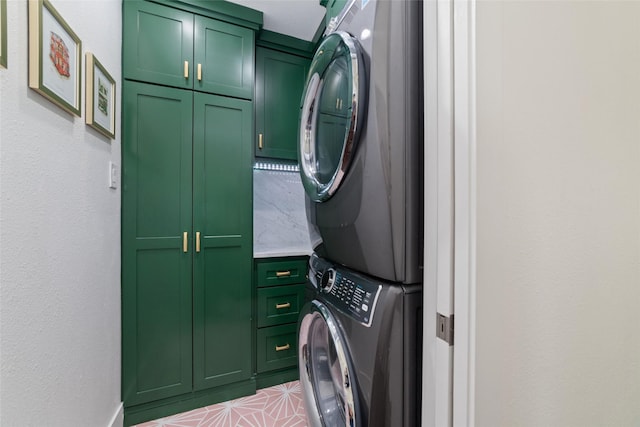 laundry area with stacked washing maching and dryer and cabinets