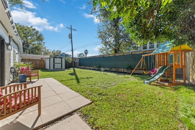 view of yard featuring a storage unit, a patio area, and a playground