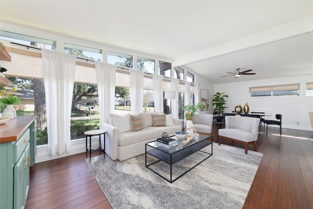 living room with ceiling fan, dark wood-type flooring, a wealth of natural light, and vaulted ceiling with beams