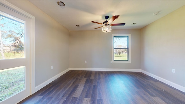 spare room featuring a wealth of natural light, ceiling fan, and dark hardwood / wood-style flooring