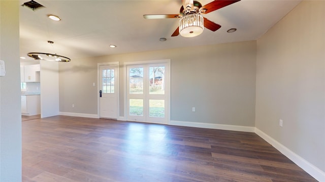 spare room featuring ceiling fan and dark wood-type flooring