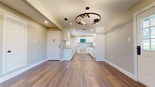 entryway with a healthy amount of sunlight, dark hardwood / wood-style floors, and an inviting chandelier