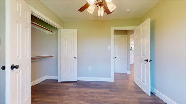 unfurnished bedroom with ceiling fan, a closet, and dark wood-type flooring