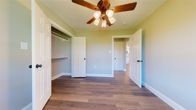 unfurnished bedroom featuring ceiling fan, a closet, and dark wood-type flooring