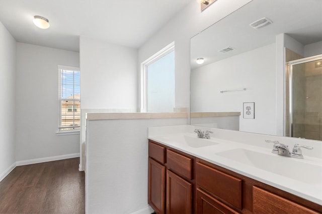 bathroom featuring hardwood / wood-style flooring, vanity, and a shower with shower door