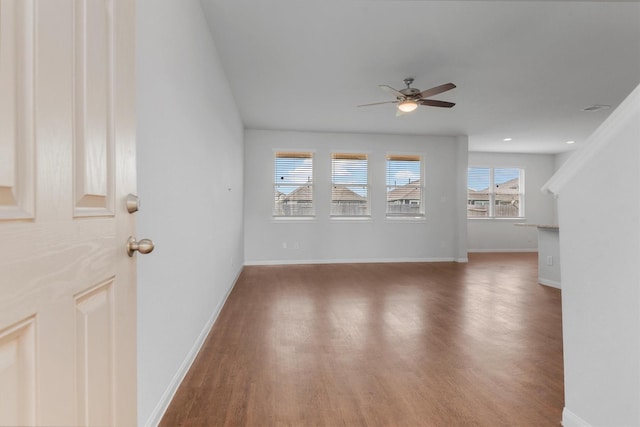 unfurnished living room featuring dark hardwood / wood-style floors and ceiling fan