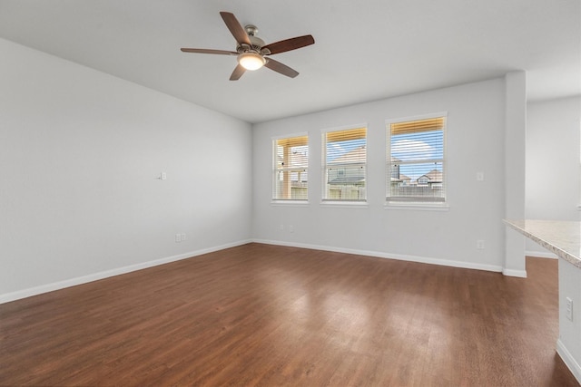 spare room featuring dark wood-type flooring and ceiling fan