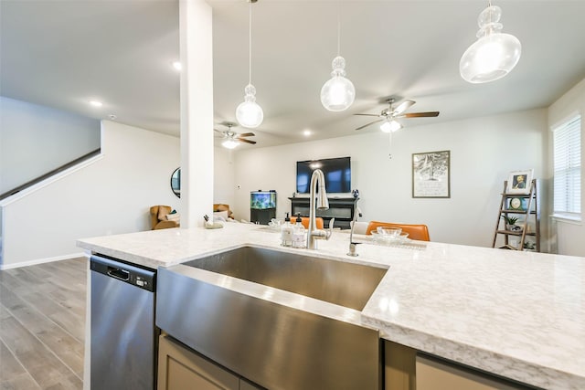 kitchen featuring stainless steel dishwasher, pendant lighting, sink, and hardwood / wood-style flooring