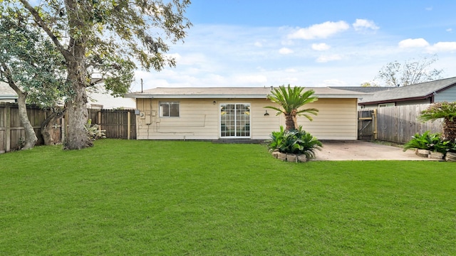 rear view of house with a lawn and a patio area