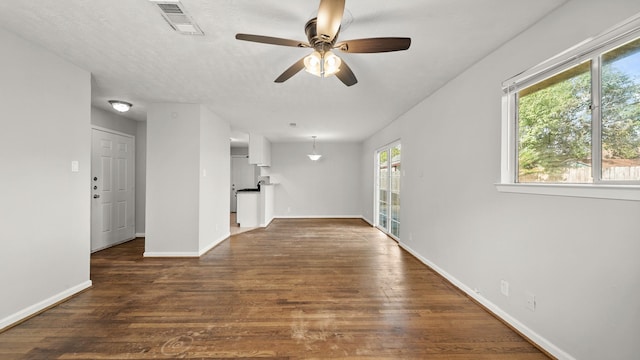 empty room with ceiling fan and dark wood-type flooring