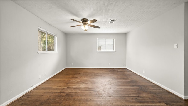 unfurnished room with ceiling fan, a healthy amount of sunlight, dark hardwood / wood-style flooring, and a textured ceiling