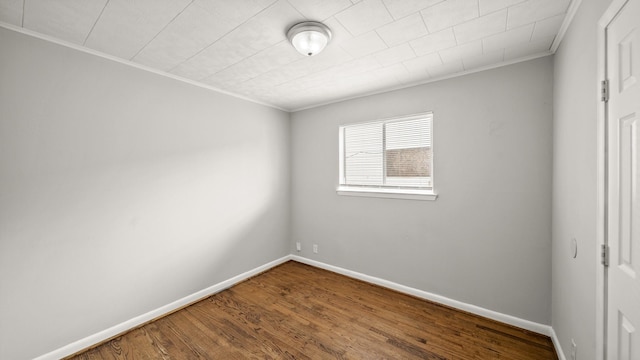 empty room with hardwood / wood-style floors and ornamental molding