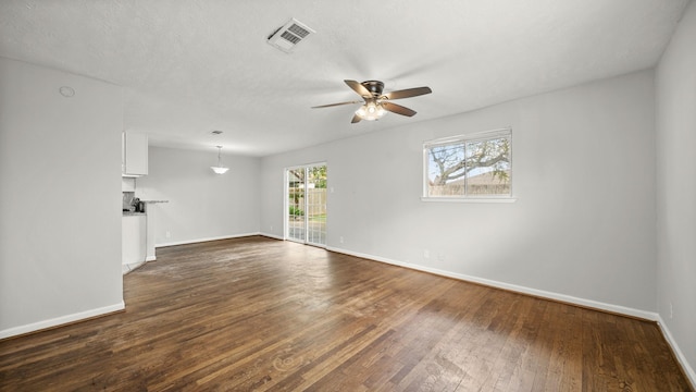 unfurnished living room with dark hardwood / wood-style floors and ceiling fan