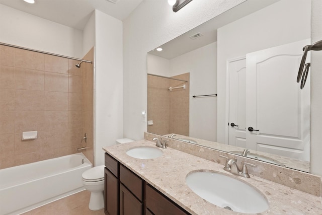 full bathroom with tile patterned floors, tiled shower / bath combo, toilet, and vanity