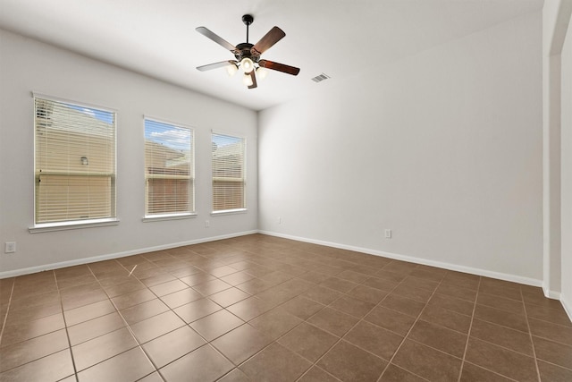 unfurnished room featuring ceiling fan and dark tile patterned floors