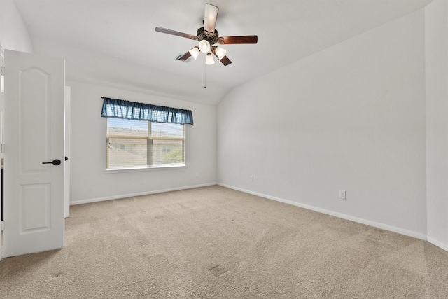 carpeted spare room featuring ceiling fan and vaulted ceiling