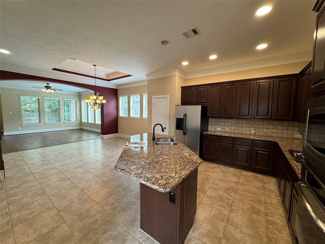 kitchen with stainless steel appliances, an island with sink, hanging light fixtures, sink, and ceiling fan with notable chandelier