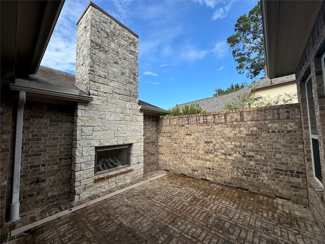 view of patio / terrace featuring an outdoor stone fireplace