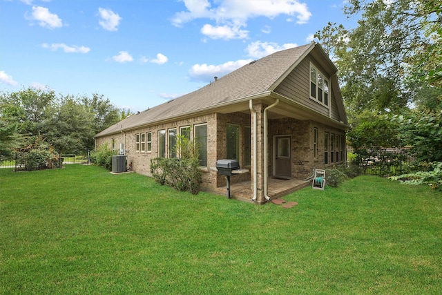 rear view of property featuring a yard, cooling unit, and a patio